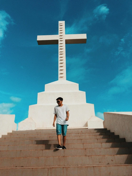 a man is standing in front of a cross, by Robbie Trevino, pexels contest winner, stairway to heaven, full body profile, vacation photo, he is about 20 years old | short