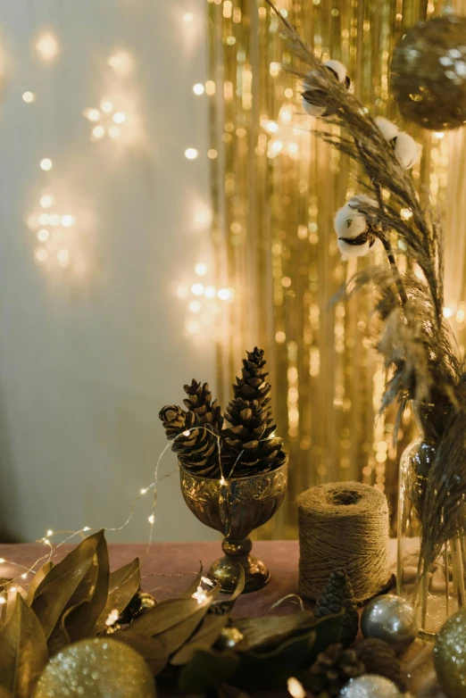 a table topped with a vase filled with christmas decorations, inspired by Elsa Bleda, trending on pexels, light and space, gold crown and filaments, studio ambient lighting, beaded curtains, harvest