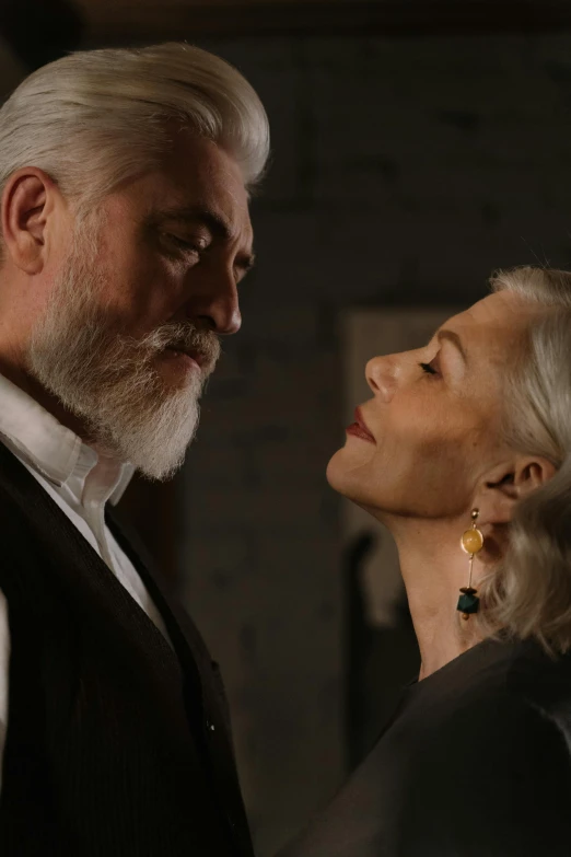 a man and a woman standing next to each other, inspired by John Collier, photorealism, grey beard, production still, love scene, video still