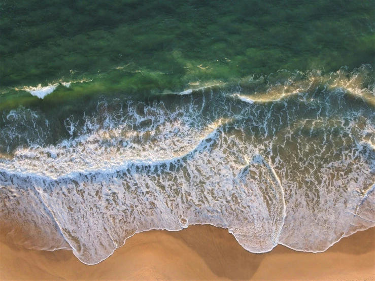 a person riding a surfboard on top of a sandy beach, a photorealistic painting, by Bernard D’Andrea, pexels contest winner, pristine rippling oceanic waves, view from helicopter, south african coast, beautiful panoramic imagery