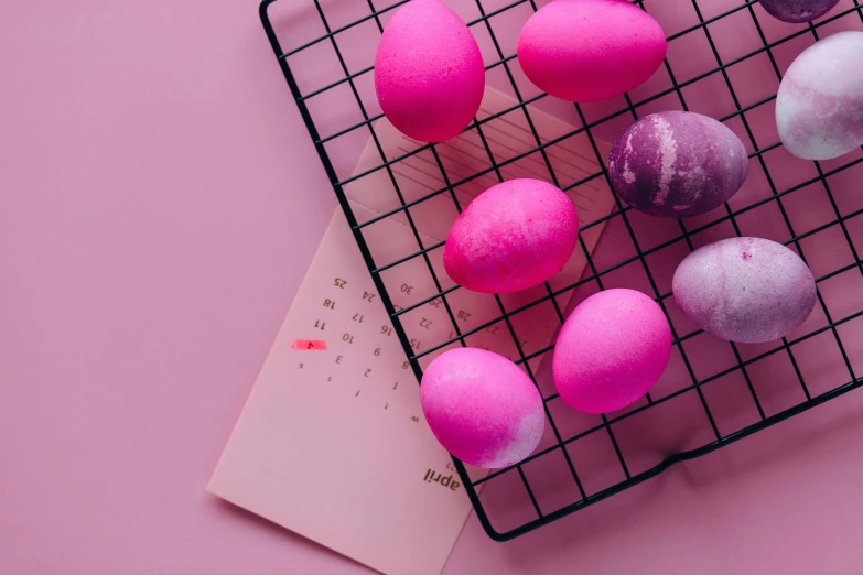 a bunch of pink and purple easter eggs on a wire rack, an album cover, by Julia Pishtar, trending on pexels, happening, female calendar, programming, a high angle shot, grid