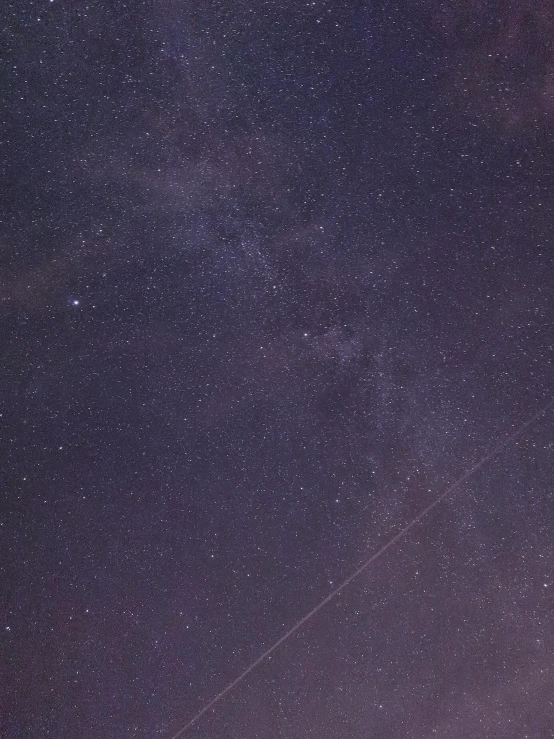 a person flying a kite in the night sky, lost in the immensity of space, looking towards the camera