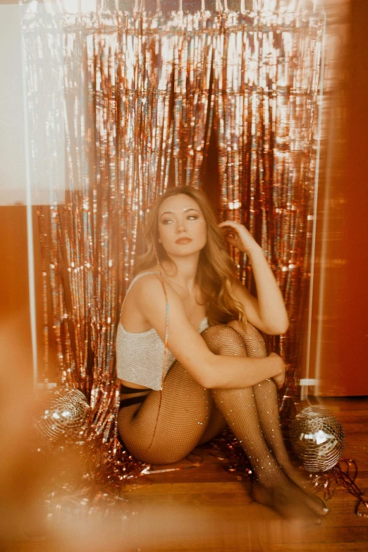 a woman sitting on the floor in front of a mirror, inspired by Elsa Bleda, unsplash contest winner, long shiny bronze brown hair, photo booth, glitter, soft red lights