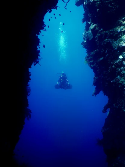 a couple of people that are in the water, mariana trench, deep crevices of stone, looking around a corner, subtle detailing