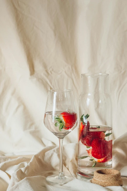 a couple of wine glasses sitting on top of a table, a still life, by Emily Shanks, trending on unsplash, strawberries, linen, tall iced tea glass, minimalist composition