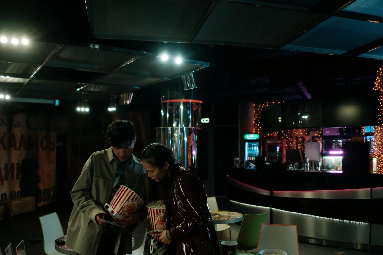 a couple of people that are standing in a room, inspired by Nan Goldin, happening, 8 0 s asian neon movie still, [ theatrical ], cosy atmosphere, scene from live action movie