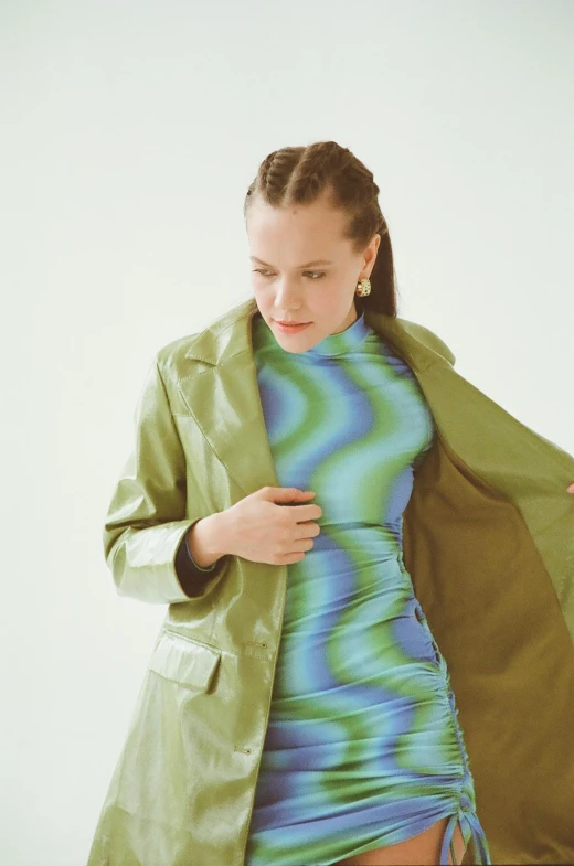 a woman in a green coat and a blue dress, trending on pexels, holographic undertones, kirsi salonen, skintight suits, 90s photo