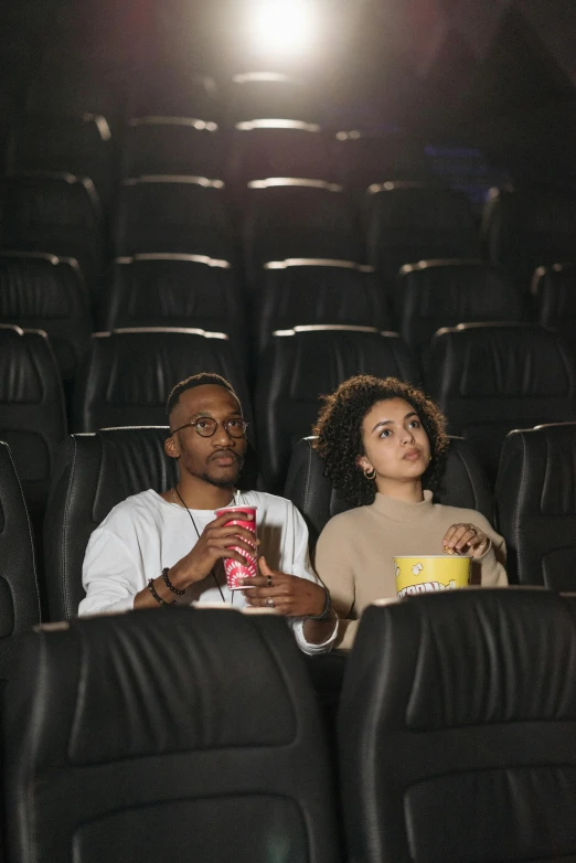 a couple of people sitting in a movie theater, square, gen z, 256435456k film, diverse