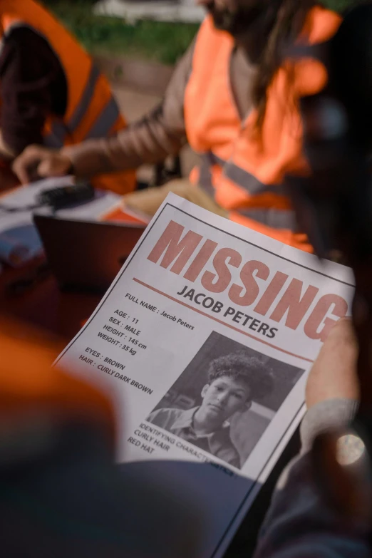 a newspaper sitting on top of a wooden table, a poster, by Jacob Toorenvliet, trending on pexels, happening, still image from tv series, missing poster, dressed as a scavenger, tracers