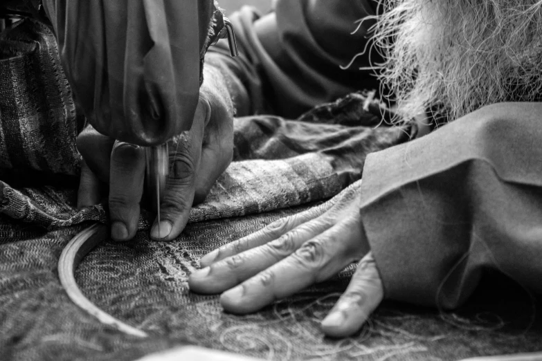 a black and white photo of a person using a sewing machine, by John Hutton, pexels, process art, old wool suit, blessing hands, weave, street photo