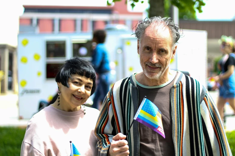 a man and a woman standing next to each other, a photo, unsplash, berlin secession, pride parade, portrait image