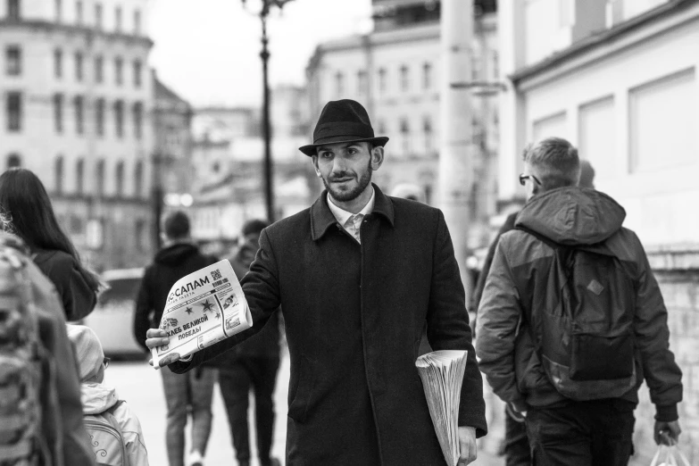 a black and white photo of a man holding a newspaper, by Emma Andijewska, pexels contest winner, street of moscow, looking cute, a suited man in a hat, fish man