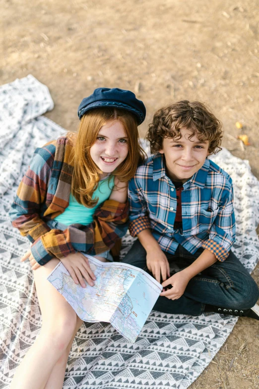 a couple of young people sitting on top of a blanket, brunette boy and redhead boy, mapbox, hollywood promotional image, kids