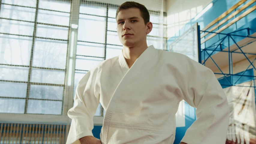 a man in a white kimono standing in a gym, portrait of tom holland, promotional image, etienne hebinger, full frame shot