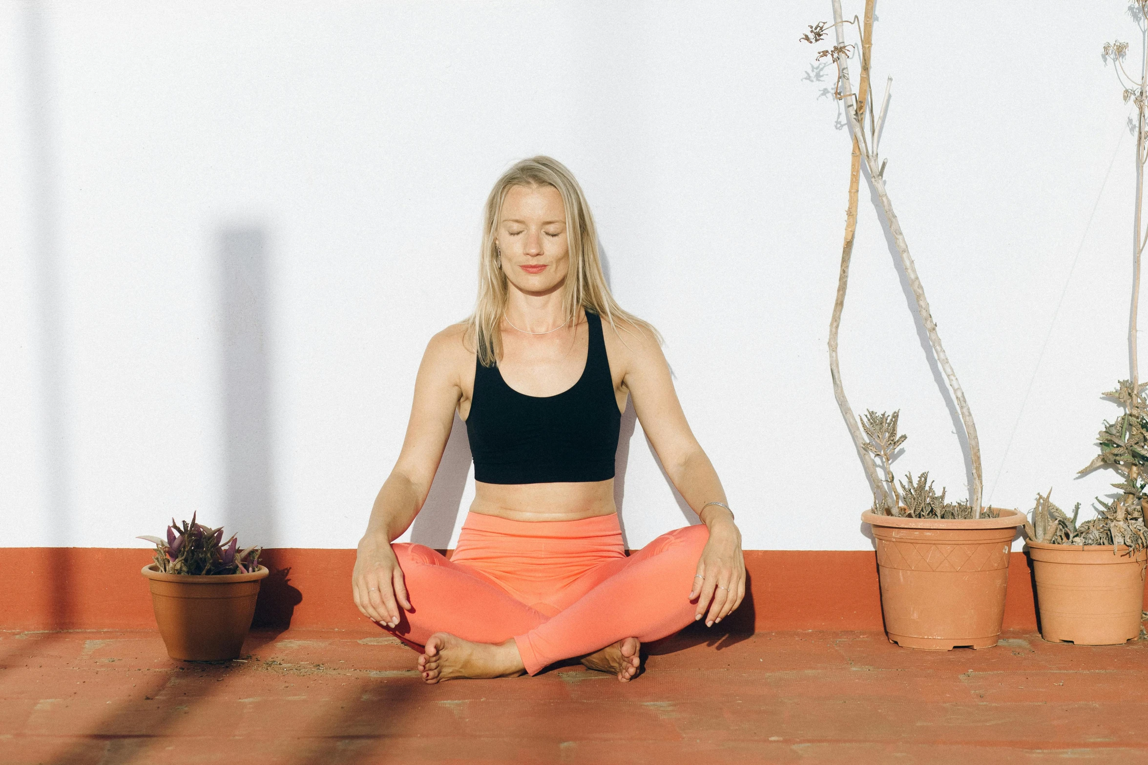 a woman sitting in the middle of a yoga pose, a portrait, by Rachel Reckitt, unsplash, terracotta, slightly sunny, low quality photo, britt marling style