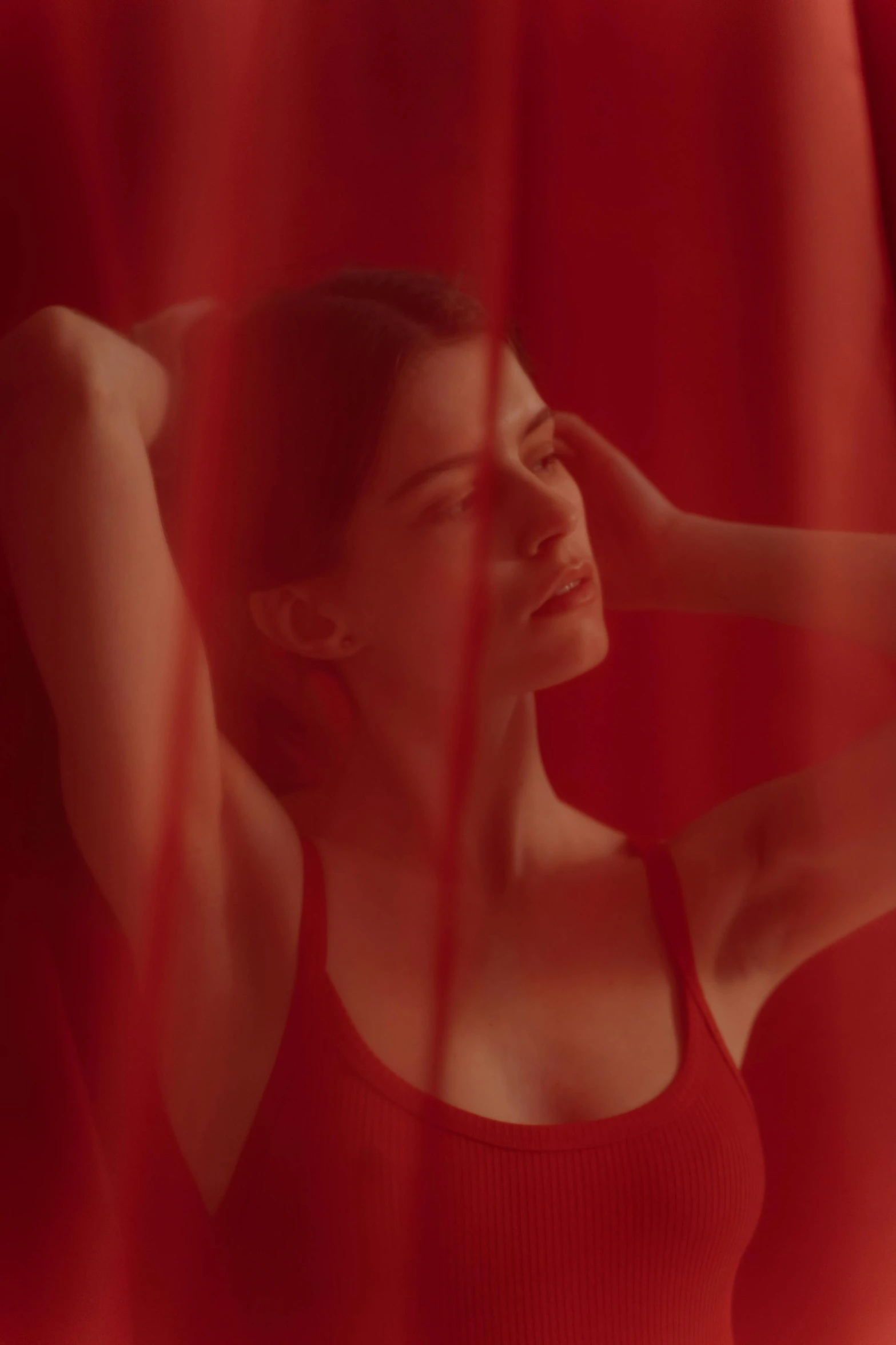 a woman standing in front of a red curtain, still from a music video, alexandra daddario, soft shadows, summertime