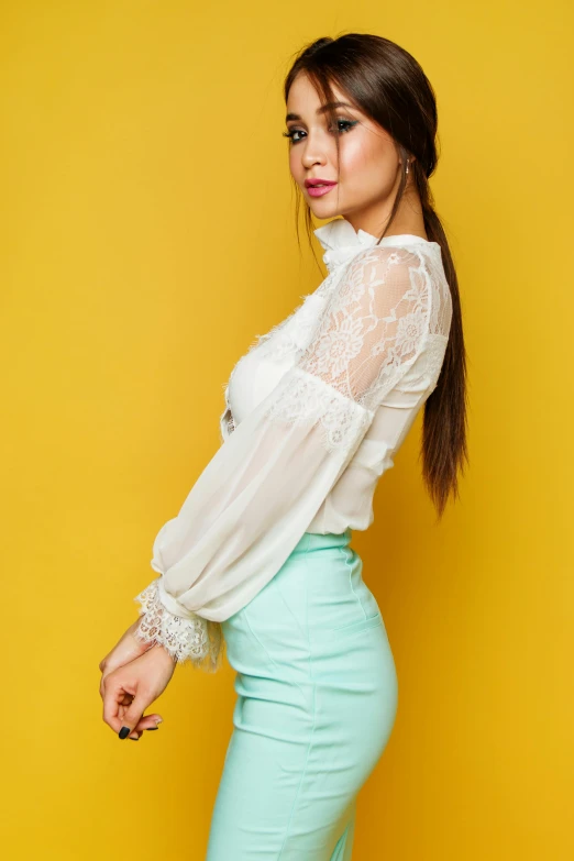 a woman standing in front of a yellow wall, trending on pexels, white lace clothing, teal skirt, beautiful young asian woman, wearing a white blouse