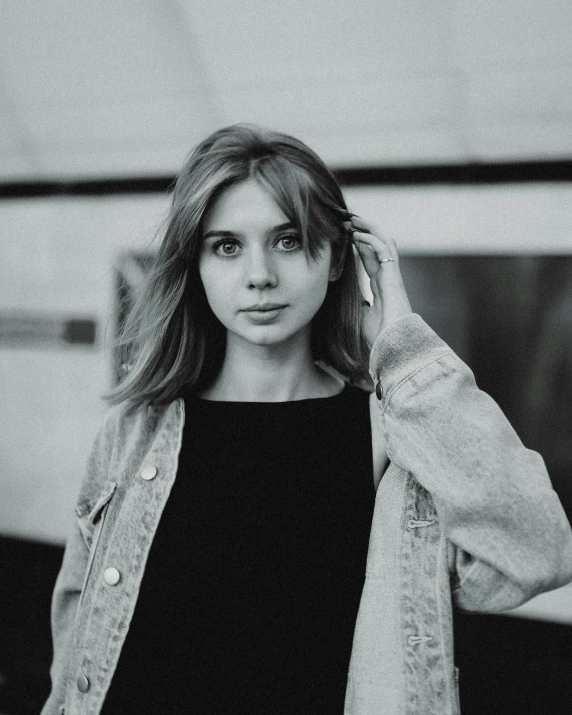 a black and white photo of a woman standing in front of a train, a black and white photo, inspired by Elsa Bleda, pexels contest winner, realism, handsome girl, imogen poots, black sweater, better known as amouranth