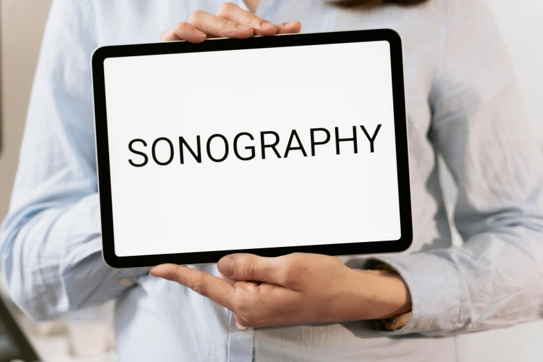 a woman holding a tablet with the word sonography on it, an album cover, inspired by Jens Søndergaard, trending on unsplash, holography, pinhole analogue photo quality, signing autographs, snoring, singularity