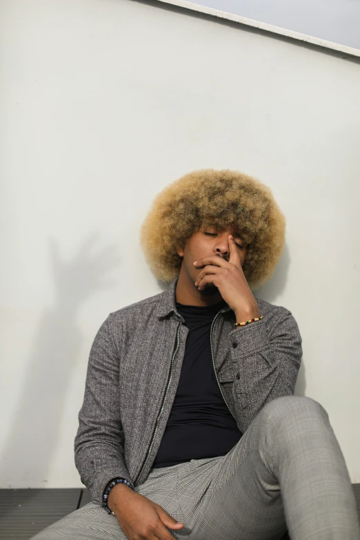 a man sitting on the ground talking on a cell phone, an album cover, trending on pexels, black arts movement, curly blond hair, facepalm, studio portrait, thinker pose