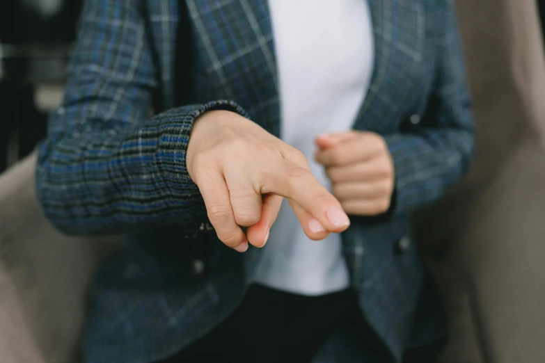 a close up of a person pointing at something, by Emma Andijewska, wearing a suits, touching her clothes, aggressive stance, lie detector test