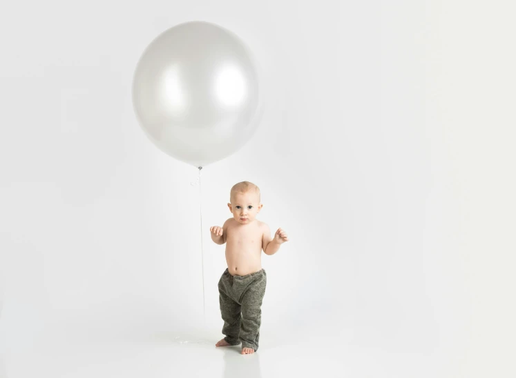 a baby standing in front of a white balloon, chrome silver, light grey, full product shot, super wide