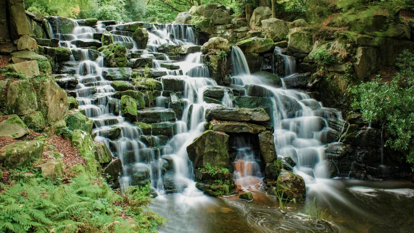 a waterfall in the middle of a lush green forest, an album cover, inspired by Thomas Struth, pexels contest winner, staggered terraces, detmold, promo image, wales