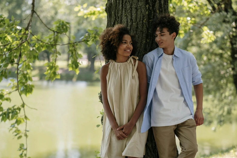 a man and a woman standing next to a tree, pexels, renaissance, imaan hammam, beautiful boy, at the waterside, young teen