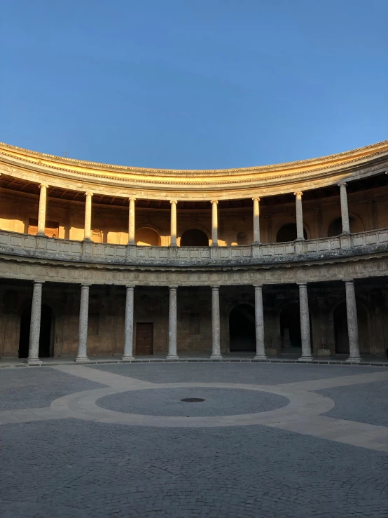 a circular building with columns and a sky background, inspired by Luis Paret y Alcazar, unsplash, renaissance, a wide open courtyard in an epic, square, golden glow, diego velazquez