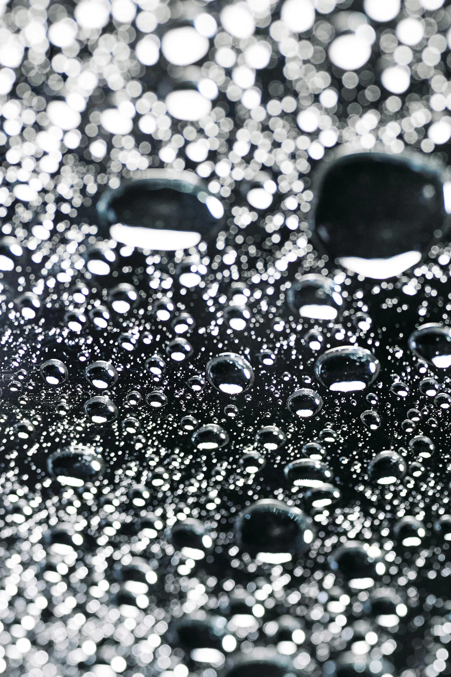 a close up of water droplets on a surface, a stipple, gradient black to silver, gleaming silver, made of smooth black goo