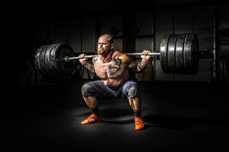 a man doing a squat with a barbell, pexels contest winner, hyperrealism, full - body tattoos, knee pads, australian, giant legs