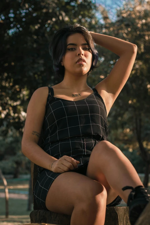 a woman sitting on top of a tree stump, inspired by Elsa Bleda, trending on pexels, realism, tight black tank top and shorts, on a checkered floor, wearing black camisole outfit, alanis guillen