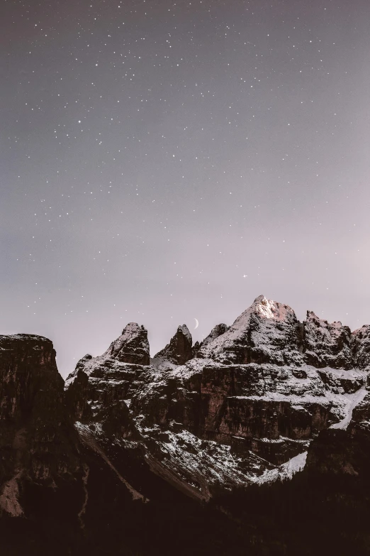 a person standing on top of a snow covered mountain, a matte painting, pexels contest winner, minimalism, stars and moons in the sky, in the dolomites, distant mountains lights photo, rugged | stars