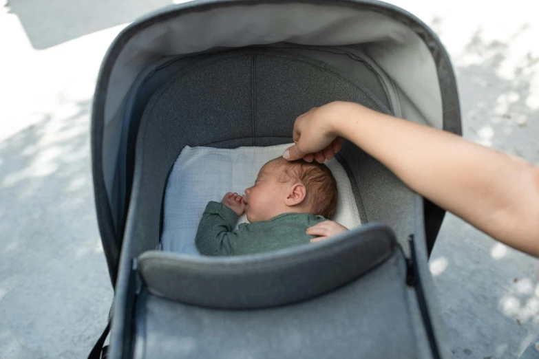 a person pushing a baby in a stroller, by Emma Andijewska, happening, hibernation capsule close-up, grey, asleep, premium quality