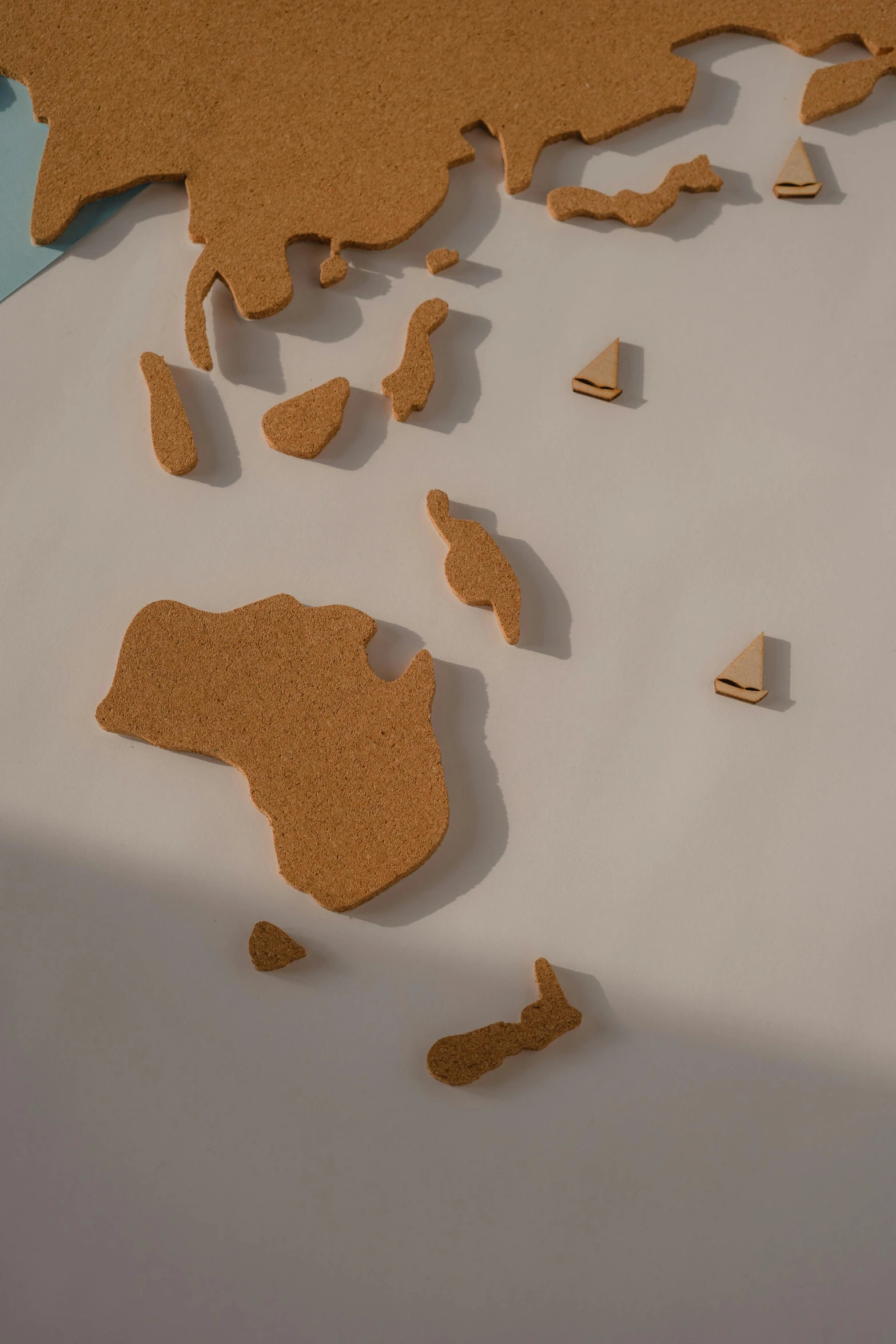 a close up of a map of the world, a jigsaw puzzle, by Daniel Lieske, trending on polycount, conceptual art, sand piled in corners, marvelous designer substance, scattered islands, cut out of cardboard