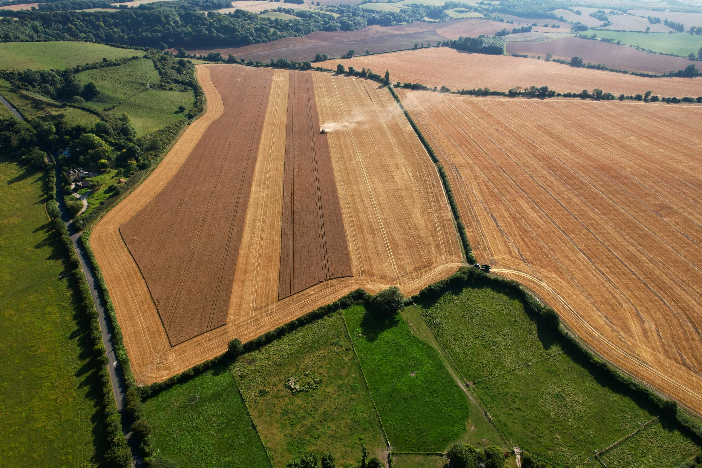 an aerial view of a plowed field, by Julian Allen, unsplash, land art, madgwick, wheat field behind the house, cranbow jenkins, photo from the dig site