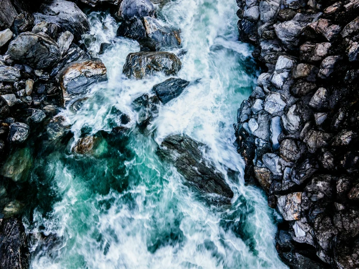 a river running through a lush green forest, an album cover, by Jacob Toorenvliet, pexels contest winner, waves crashing at rocks, high angle close up shot, rocks and metal, uttarakhand