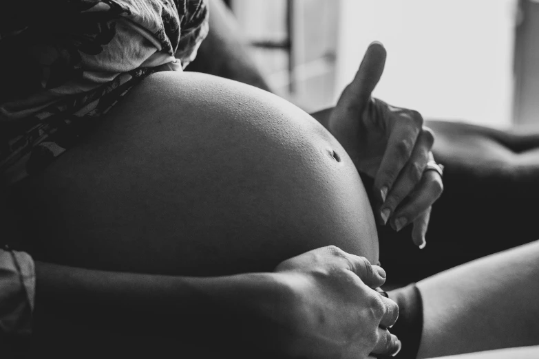 a black and white photo of a pregnant woman, pexels, thumb up, babies in her lap, realistic detail, animation