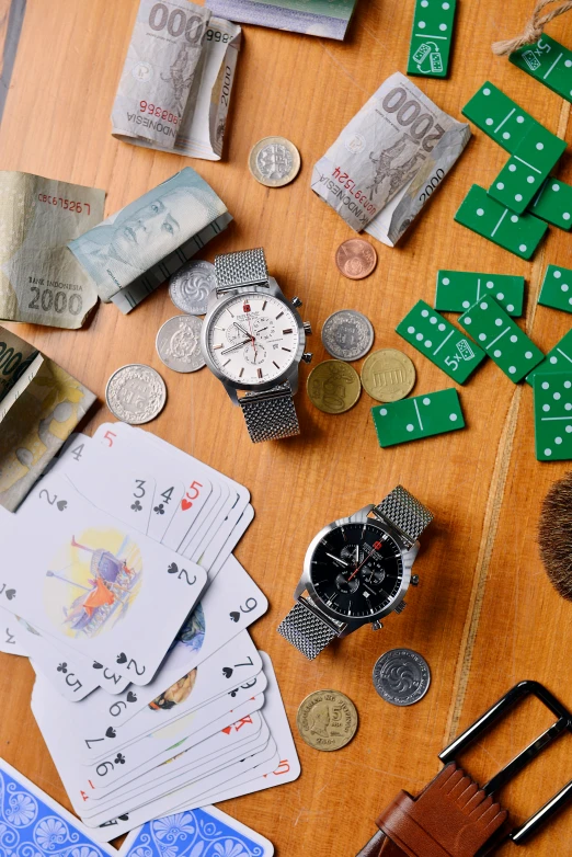 a wooden table topped with lots of assorted items, by Jang Seung-eop, unsplash, photorealism, playing cards, watch photo, photographed for reuters, money