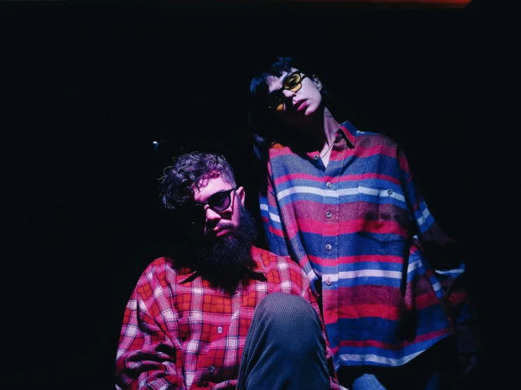 a couple of men standing next to each other, an album cover, by Winona Nelson, pexels, cynthwave, flannel, wearing red tainted glasses, live