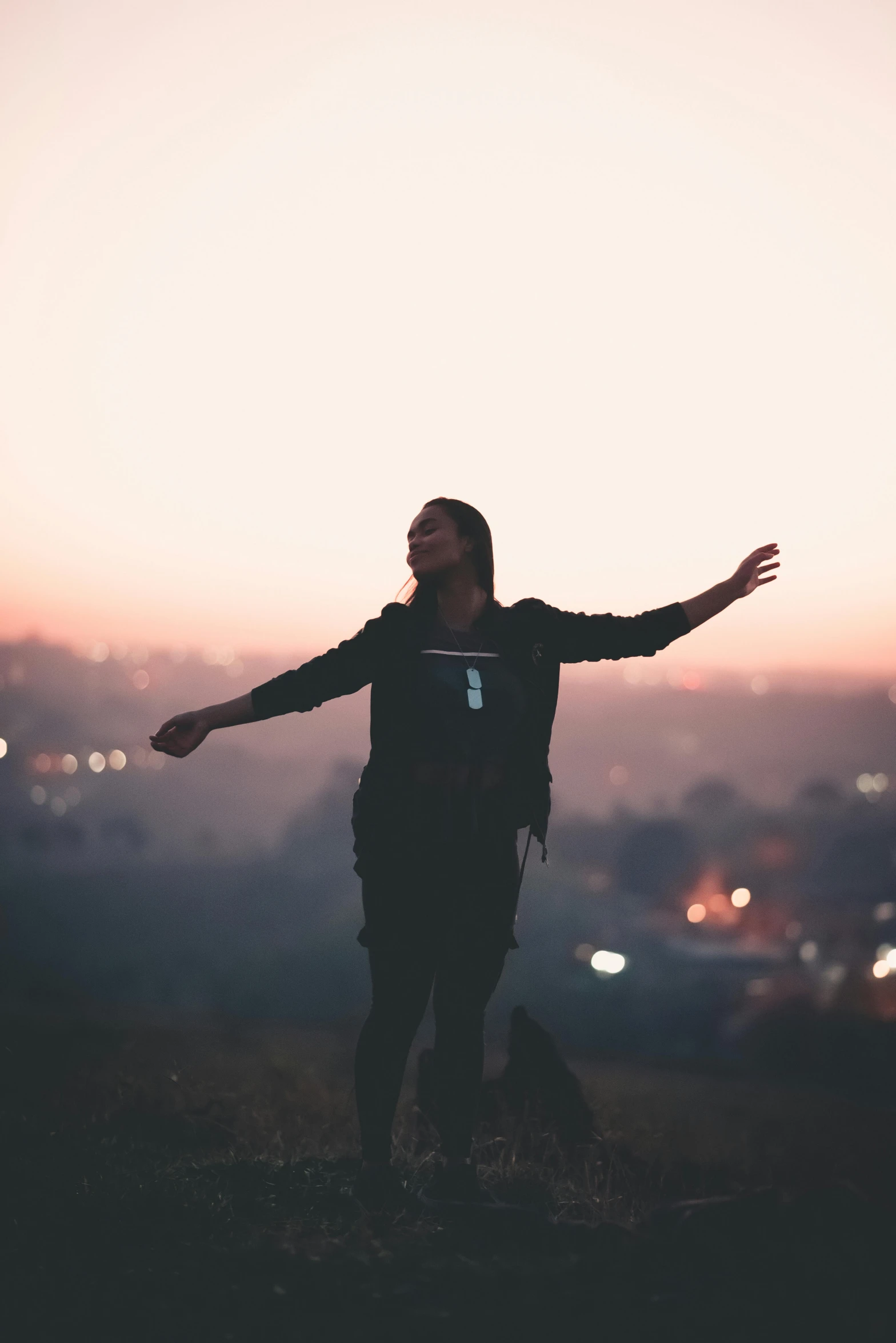 a person standing on top of a hill with their arms outstretched, pexels contest winner, happening, city morning, moody hazy lighting, satisfied pose, music video