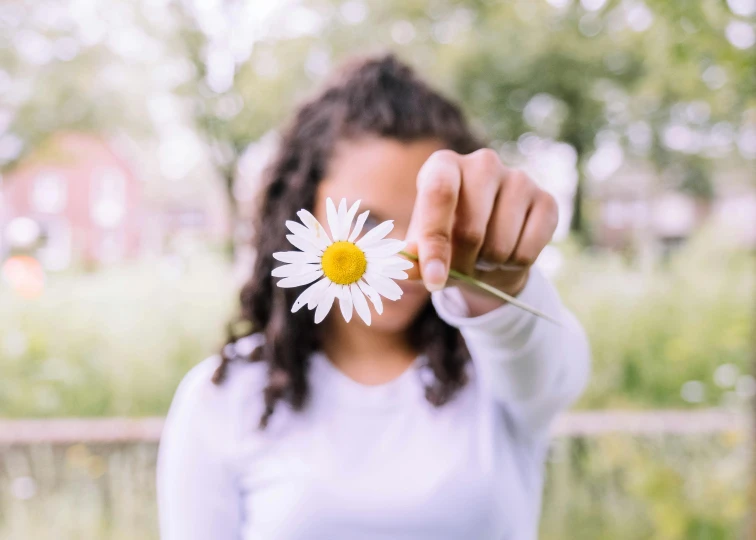 a woman holding a flower in front of her face, pexels contest winner, holding daisy, raising an arm, avatar image, white