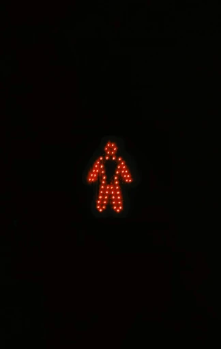 a close up of a traffic light in the dark, inspired by Bruce Nauman, reddit, ( ( spiderwoman ) ), pictogram, intact humanoid servo, reddish