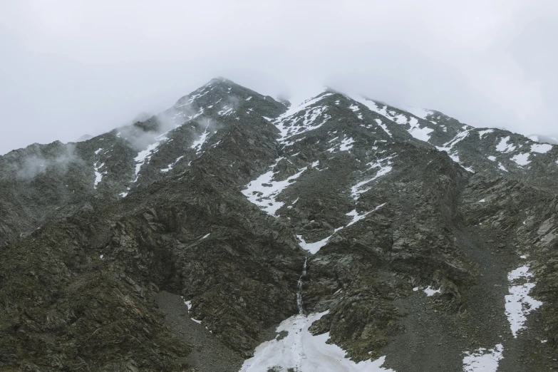 a group of people standing on top of a snow covered mountain, ultrawide image, under a gray foggy sky, nature photo, trending photo