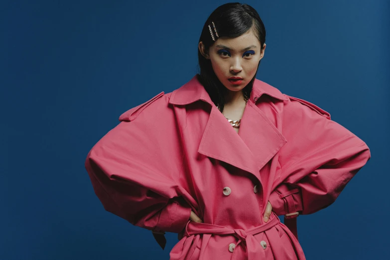 a woman in a pink coat posing for a picture, an album cover, inspired by Xia Chang, trending on pexels, pop art, trench coat, zendaya, looking directly at the viewer, kiko mizuhara