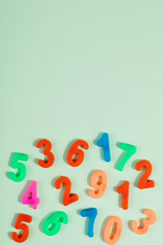 a bunch of colorful numbers on a white surface, trending on pexels, teal studio backdrop, green bright red, toys, album cover