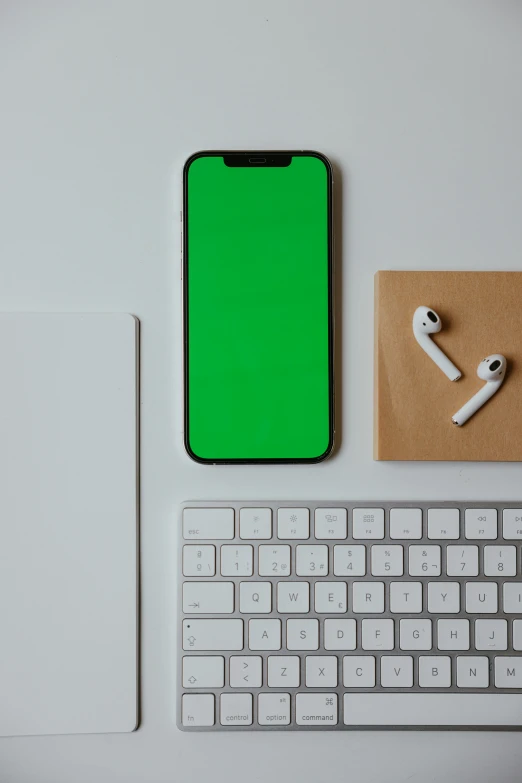 a cell phone sitting on top of a desk next to a keyboard, a computer rendering, trending on pexels, green color palette, square, thumbnail, airpods