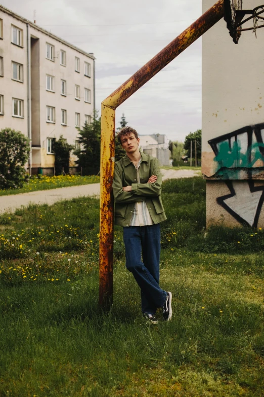 a woman standing next to a basketball hoop, an album cover, by Attila Meszlenyi, graffiti, young man, high quality photo, vitalik buterin, standing in a grassy field