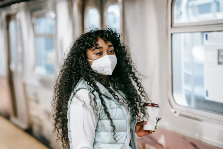a woman wearing a face mask and holding a cup of coffee, trending on pexels, graffiti, a black man with long curly hair, sat down in train aile, avatar image, respirator