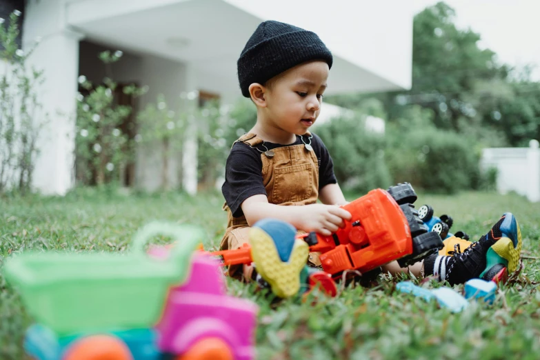 a little boy sitting in the grass playing with toys, pexels contest winner, vehicle, geometrically correct, gen z, casually dressed